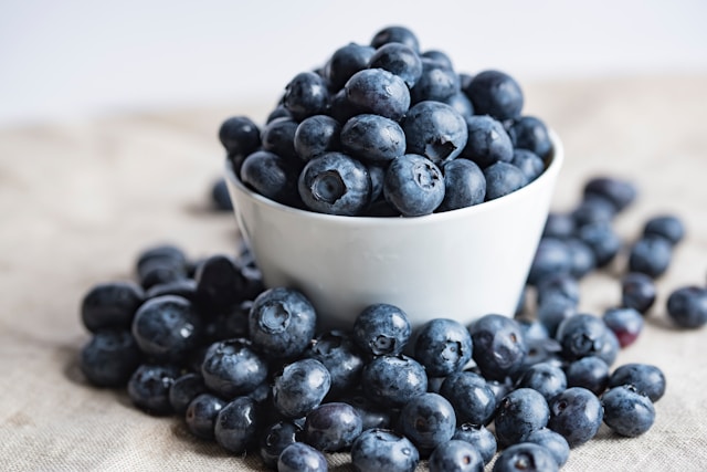 Fresh blueberries in a bowl and on the table